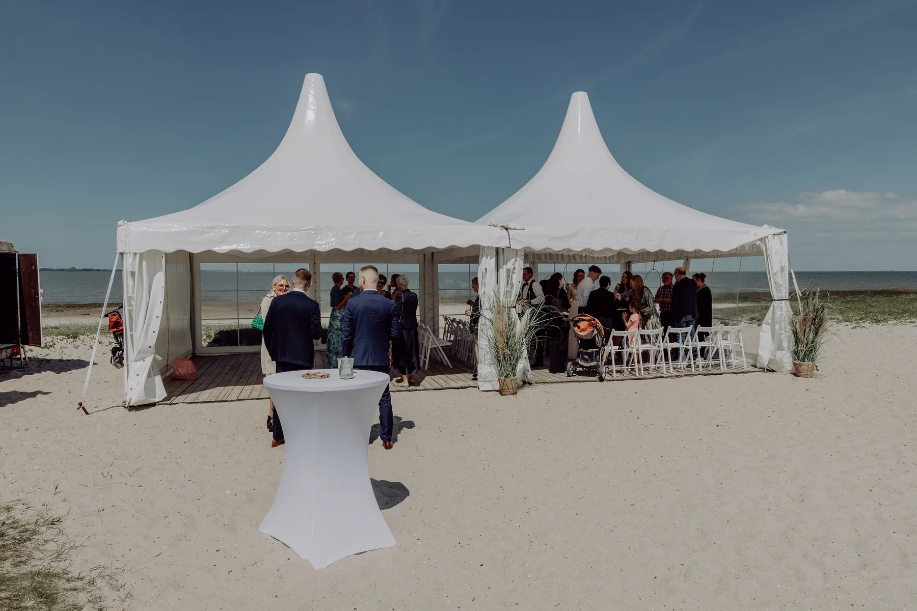 Kleine Hochzeitsgesellschaft in einem Zelt am Strand